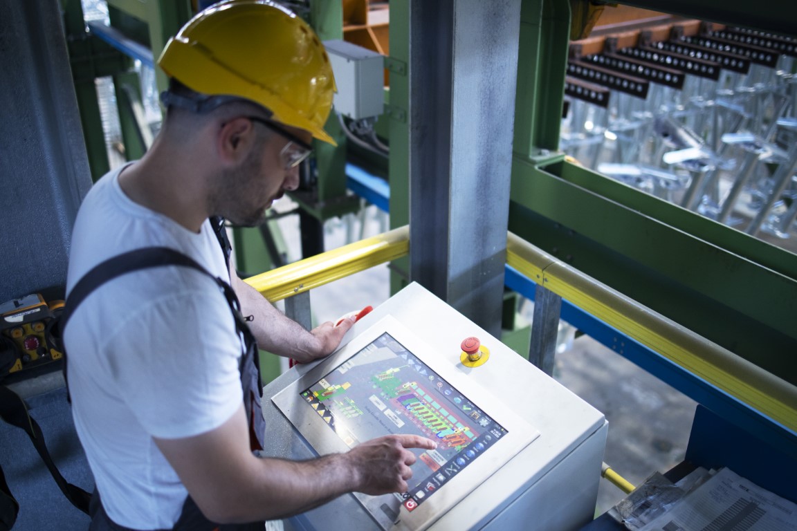 factory worker monitoring industrial machines production remotely control room Medium